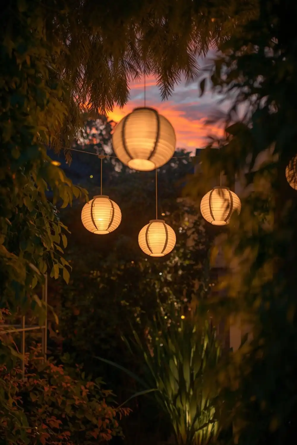 Hanging lanterns glow during colorful sunset