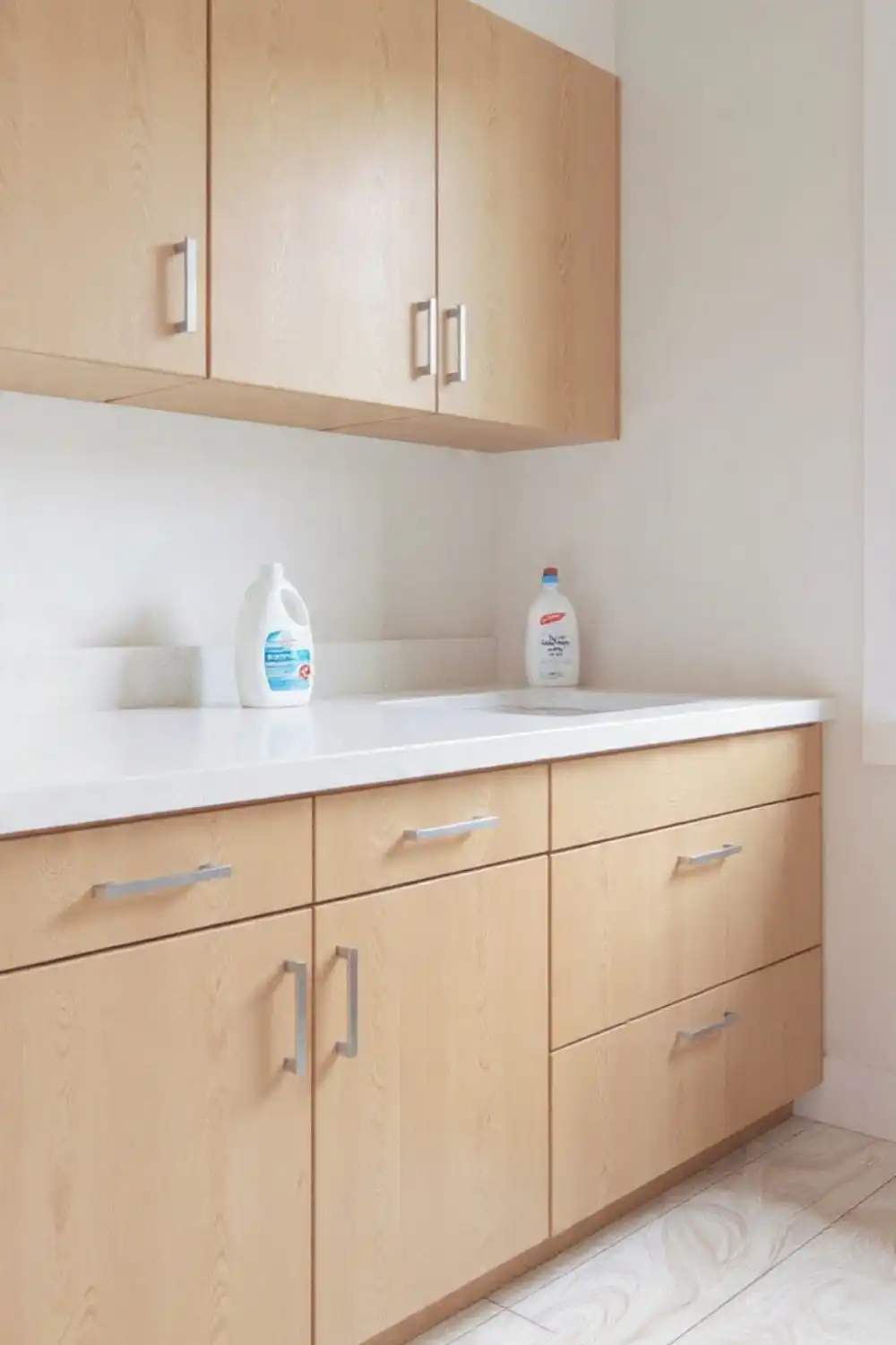 Modern wooden kitchen cabinets with cleaning supplies