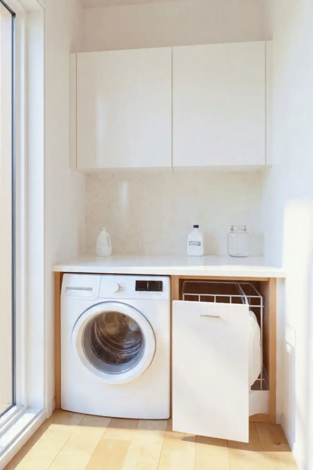 Compact laundry room with washer and cabinets.