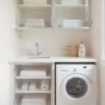 White laundry room with washer and towels.