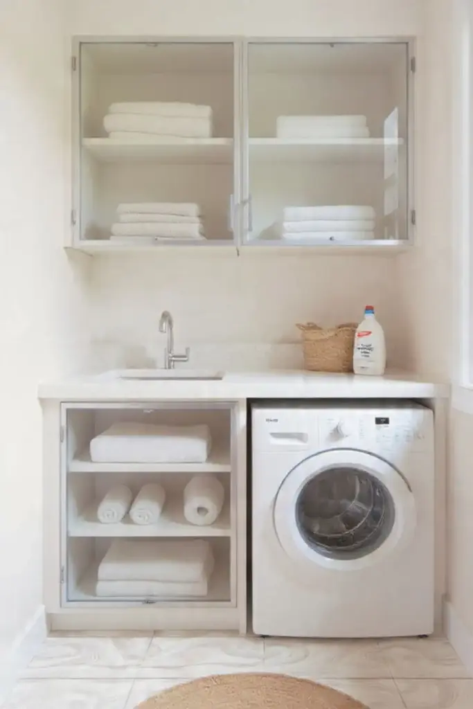 White laundry room with washer and towels.