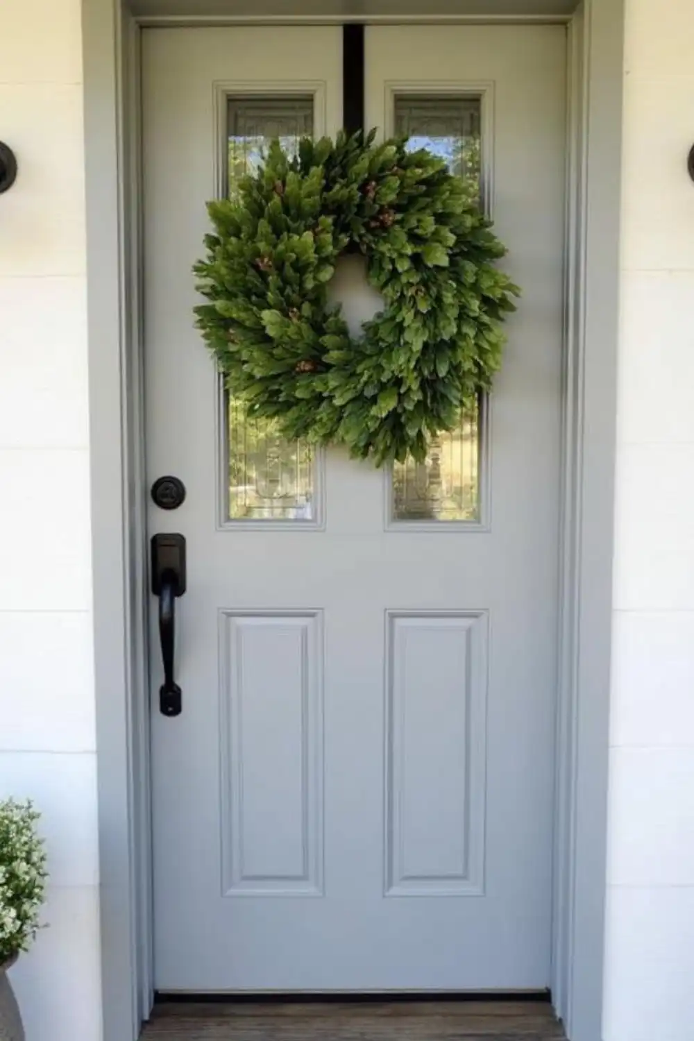 Gray door with green wreath, modern handle.