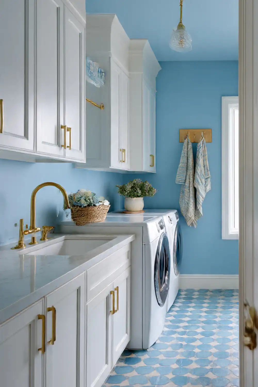 Blue and white laundry room with gold fixtures.