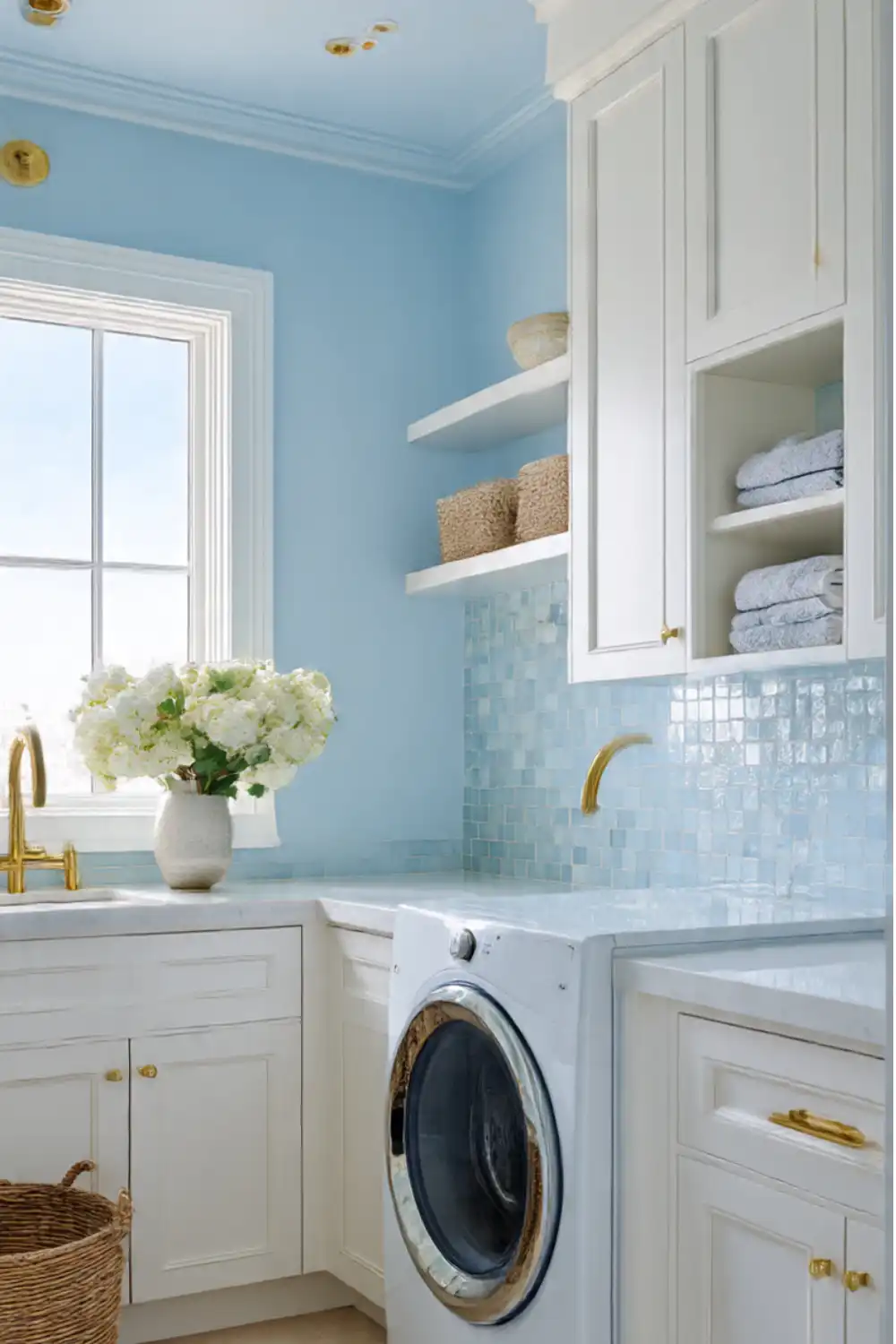 Bright laundry room with blue tiles and gold accents.