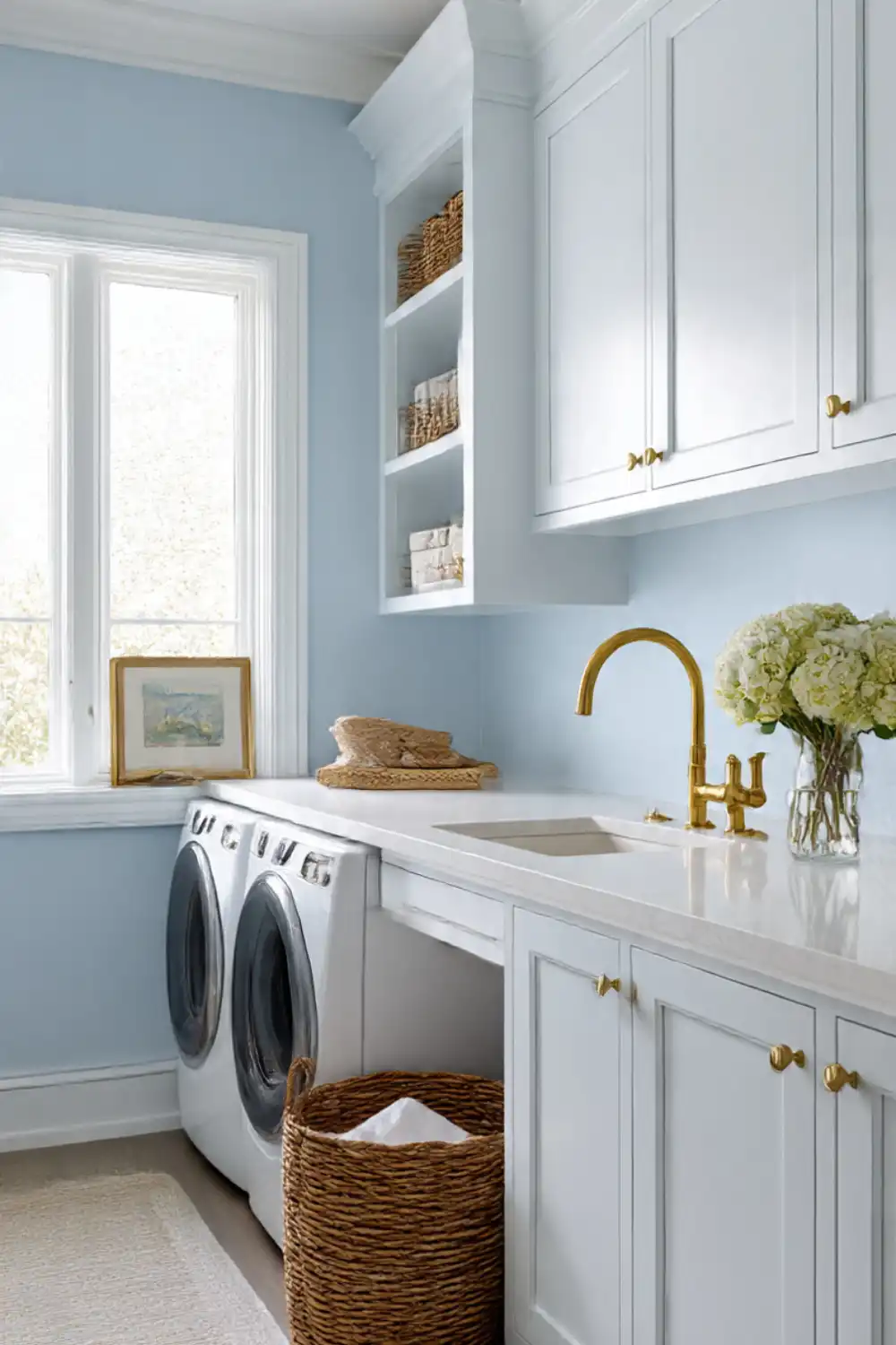 Airy laundry room with blue walls and gold accents.